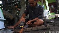 Ghufron sedang menajamnkan sabit dengan menggunakan gerinda besi. Sebelum dijual kepasaran.