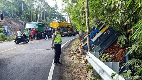 Truk bermuatan balok terbalik di Jalan Denpasar-Gilimanuk, Tabanan, Bali.