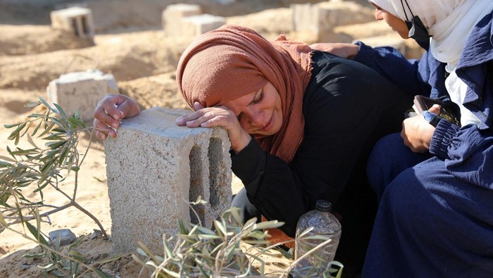 A Palestinian woman reacts at the grave of her son killed in an Israeli strike, amid the ongoing conflict between Israel and the Palistinian Islamist group Hamas, in Khan Younis in the southern Gaza Strip, January 18, 2024. REUTERS/Arafat Barbakh     TPX IMAGES OF THE DAY