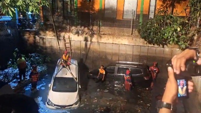Dua unit mobil tercebur ke saluran irigasi di Palmerah, Jakarta Barat.