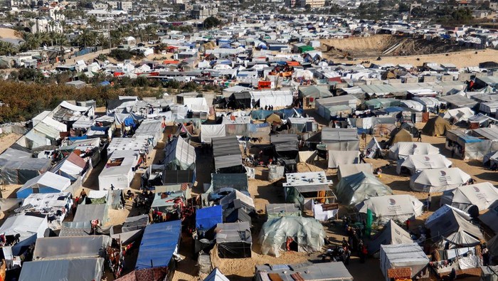 Foto Udara Kamp Pengungsian Rafah People stand near a tent camp where displaced Palestinians, who fled their houses due to Israeli strikes, take shelter, in Rafah in the southern Gaza Strip January 21, 2024. REUTERS/Saleh Salem
