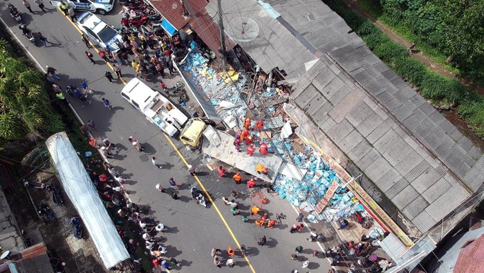 Kecelakaan beruntun di Jalan Raya Puncak Bogor Foto udara sejumlah petugas mengevakuasi kendaraan yang terlibat tabrakan beruntun di ruas Jalan Raya Tugu, Puncak, Kecamatan Cisarua, Kabupaten Bogor, Jawa Barat, Selasa (23/1/2024). Menurut Sat Lantas Polres Bogor kecelakaan beruntun yang diduga akibat gagal fungsi rem truk dan melibatkan sembilan kendaraan rusak berat diantaranya satu unit truk, empat kendaraan roda empat, empat kendaraan roda dua serta dua bangunan rusak parah dengan 16 korban luka. ANTARA FOTO/Yulius Satria Wijaya/Spt.