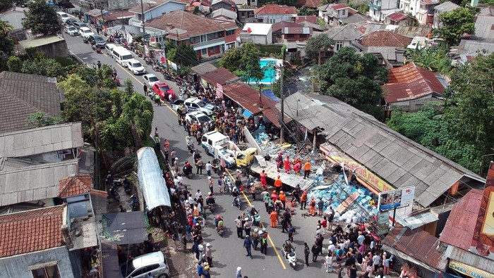 Foto udara sejumlah petugas mengevakuasi kendaraan yang terlibat tabrakan beruntun di ruas Jalan Raya Tugu, Puncak, Kecamatan Cisarua, Kabupaten Bogor, Jawa Barat, Selasa (23/1/2024). Menurut Sat Lantas Polres Bogor kecelakaan beruntun yang diduga akibat gagal fungsi rem truk dan melibatkan sembilan kendaraan rusak berat diantaranya satu unit truk, empat kendaraan roda empat, empat kendaraan roda dua serta dua bangunan rusak parah dengan 16 korban luka.  ANTARA FOTO/Yulius Satria Wijaya/Spt.