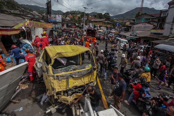 Foto udara sejumlah petugas mengevakuasi kendaraan yang terlibat tabrakan beruntun di ruas Jalan Raya Tugu, Puncak, Kecamatan Cisarua, Kabupaten Bogor, Jawa Barat, Selasa (23/1/2024). Menurut Sat Lantas Polres Bogor kecelakaan beruntun yang diduga akibat gagal fungsi rem truk dan melibatkan sembilan kendaraan rusak berat diantaranya satu unit truk, empat kendaraan roda empat, empat kendaraan roda dua serta dua bangunan rusak parah dengan 16 korban luka.  ANTARA FOTO/Yulius Satria Wijaya/Spt.