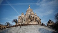 Pemandangan taman yang tertutup salju dekat Basilika Sacre Coeur di Butte Montmartre di Paris.