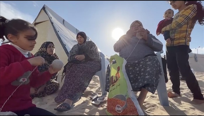 Nenek di Gaza merajut topi dari wol usang agar tak kedinginan.