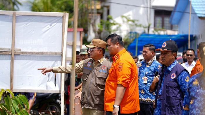 Pj Bupati Banyuasin Hani S Rustam bersama Sekda Erwin Ibarhim meninjau banjir.