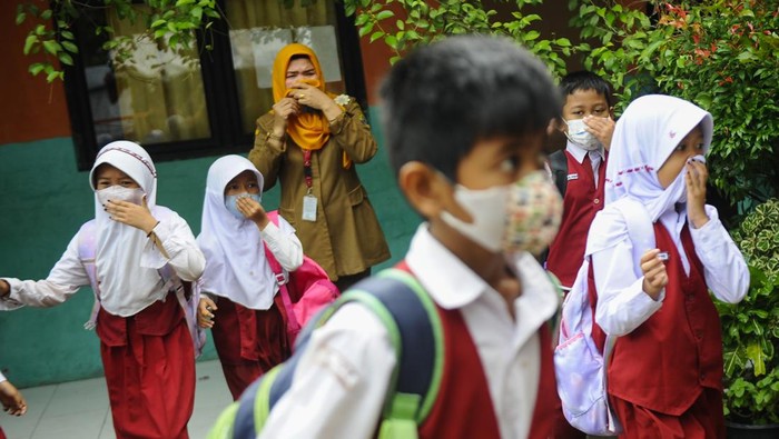 Ratusan Siswa Dipulangkan Akibat Bau Menyengat dari Pabrik Kimia Cilegon Seorang guru mengamati siswa yang dipulangkan lebih awal dampak bau gas di SDN Kepuh, Kota Cilegon, Banten, Selasa (23/1/2024). Sebanyak 232 siswa di sekolah tersebut terpaksa dipulangkan lebih awal karena masih adanya bau menyengat dari pabrik kimia PT Chandra Asri yang berjarak sekitar 5 kilometer dari sekolah itu. ANTARA FOTO/Muhammad Bagus Khoirunas/wpa.