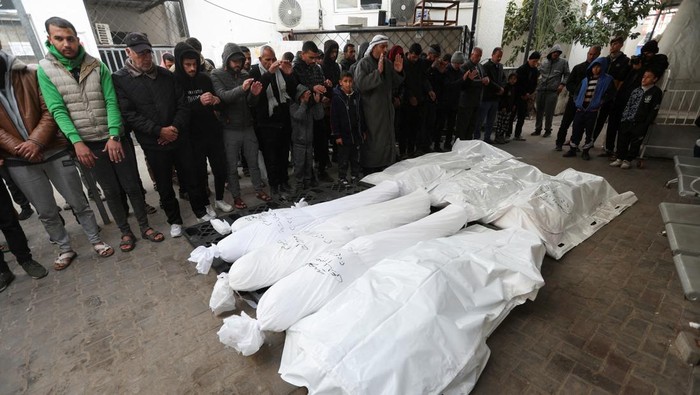 Mourners pray next to the dead bodies including four Palestinians killed in an Israeli strike on a car, amid the ongoing conflict between Israel and the Palestinian Islamist group Hamas, in Rafah in the southern Gaza Strip, January 21, 2024. REUTERS/Ibraheem Abu Mustafa REFILE - CORRECTING INFORMATION FROM BODIES OF PALESTINIANS KILLED IN AN ISRAELI STRIKE TO DEAD BODIES INCLUDING FOUR PALESTINIANS KILLED IN AN ISRAELI STRIKE ON A CAR