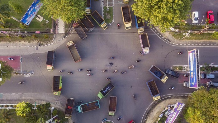 Foto udara seorang pengemudi berjalan di depan deretan truk pengangkut batu bara yang diparkir saat aksi lanjutan di halaman Kantor Gubernur Jambi, Telanaipura, Jambi, Selasa (23/1/2024). Puluhan sopir pengangkut batu bara itu masih bertahan di lapangan kantor gubernur guna menuntut dibukanya kembali jalan nasional untuk dapat dilalui angkutan batu bara. ANTARA FOTO/Wahdi Septiawan/Spt.