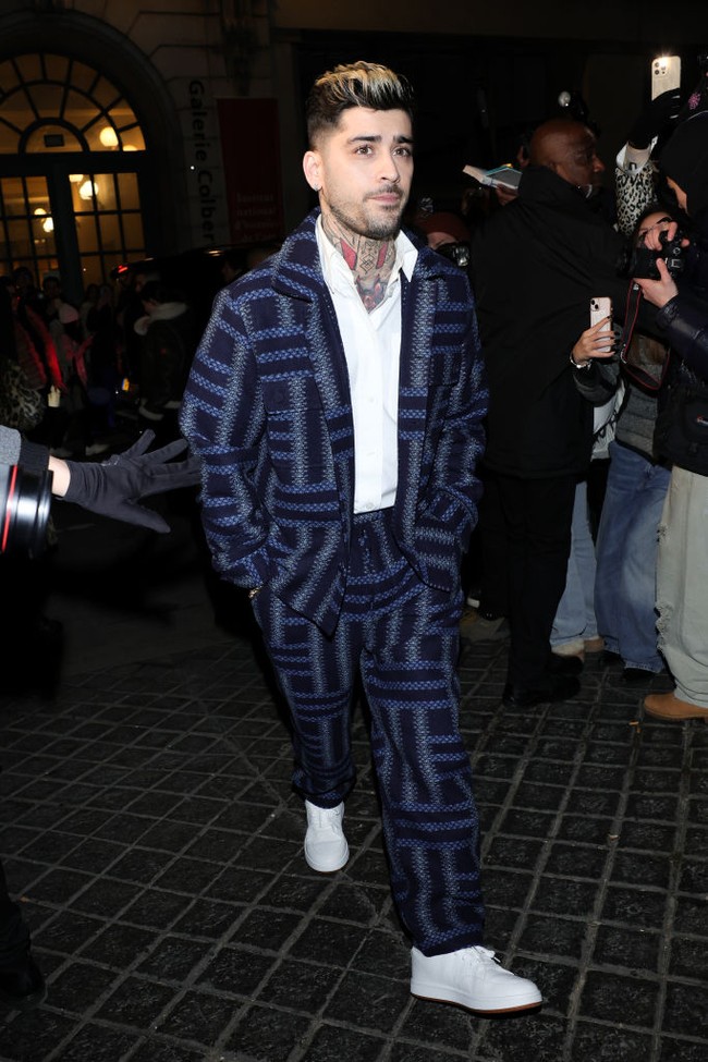 Zayn Malik tampak mengenakan sneakers putih, juga dari koleksi terbaru Kenzo. Foto: Swan Gallet/WWD via Getty Images