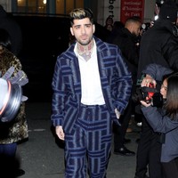 Penyanyi asal Inggris ini tampil necis dalam balutan setelan jas tweed biru tua motif geometris koleksi Kenzo. Foto: Swan Gallet/WWD via Getty Images