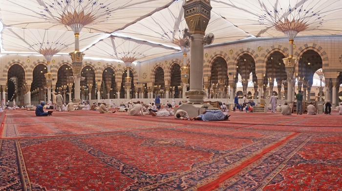 Medina, Saudi Arabia - March 8, 2015: Muslims rest and pray inside Nabawi mosque. Nabawi Mosque is the second holiest mosque in Islam and here is Prophet Muhammad is laid to rest