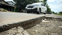 Pengendara hanya melewati satu lajur saat melintas di jalan rusak tersebut.