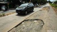 Pengendara melintas di Jalan I Gusti Ngurah Rai Bekasi yang rusak, Rabu (24/1/2024).