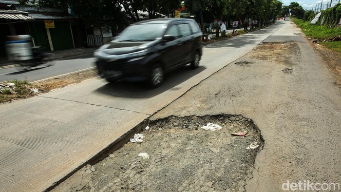 Hati-hati! Jalanan di Kranji Ini Membahayakan Pengendara melintas di Jalan I Gusti Ngurah Rai, Kranji, Bekasi, Rabu (24/1/2024). Akses jalan penghubung Jakarta dan Bekasi ini nampak rusak dan membahayakan.