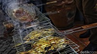 Aksi bakar ikan dilakukan di halaman samping Rumah Pemenangan Timnas AMIN.  