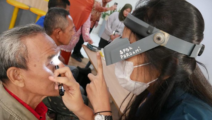 Direktur Utama Bank Mandiri Taspen Elmamber Sinaga (kanan), Komisaris Utama Mustaslimah (kedua kanan), dan aktris Lydia Kandou (tengah) menyaksikan pemeriksaan kesehatan mata peserta operasi katarak oleh tenaga medis di Graha Mantap, Jakarta, Rabu (24/1/2024).