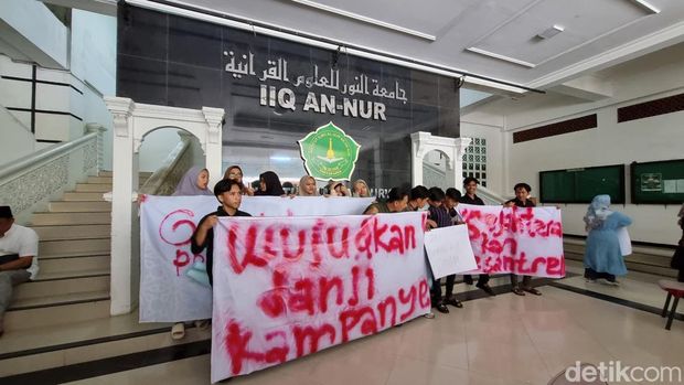 Mahasiswa Institut Ilmu Al-Qur'an (IIQ) An-Nur di Ngrukem, Sewon, Bantul membentangkan spanduk bertuliskan 'Wujudkan janji kampanye' dan 'Sejahterakan pesantren' saat Ganjar mengunjungi kampus IIQ, Kamis (25/1/2024).