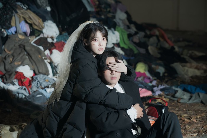 Foto belakang layar MV IU Love Wins All yang diperankan IU dan V BTS. MV ini disutradarai Um Tae Hwa dari film Concrete Utopia.