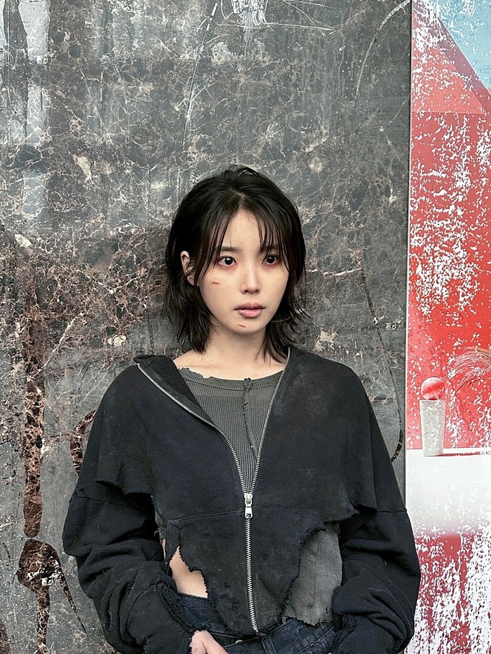 Foto belakang layar MV IU Love Wins All yang diperankan IU dan V BTS. MV ini disutradarai Um Tae Hwa dari film Concrete Utopia.