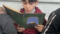Mahmoud Siam (7), salah satu murid mengikuti kelas menghafal surah An Naba. Dengan mengikuti kelas belajar Al-Quran, aku berusaha memanfaatkan waktu luangnya sebaik-baiknya karena sudah lebih dari tiga bulan tidak bersekolah, kata dia. (Foto: Instagram @rabie_noqaira)