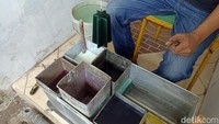 Dedy Wirabuana, perajin lilin ukir asal Blitar sedang melakukan proses pewarnaan dengan mecelupkan beberapa warna.