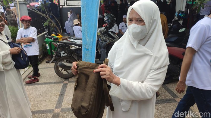 Mardiana yang menunjukkan tas selempangnya yang terbelah saat menunggu Anies Baswedan di BKB Palembang.