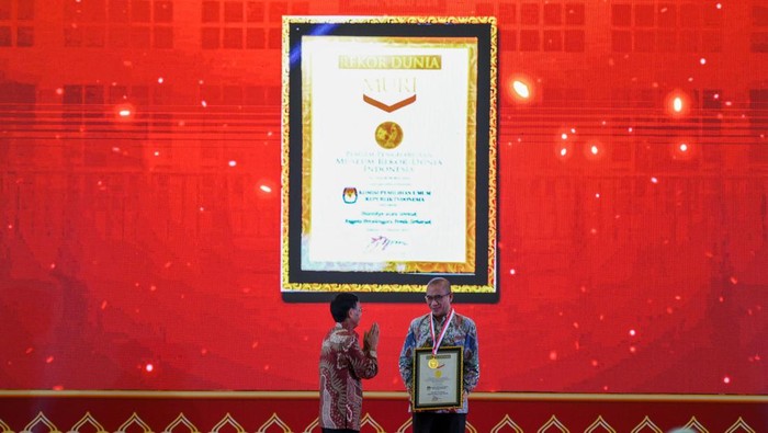 Ketua KPU RI Hasyim Asy'ari (kanan) menerima penghargaan dari Direktur Operasional MURI Yusuf Ngadri (kiri) saat acara Pelantikan Serentak KPPS dan Penganugerahan Rekor MURI di Merlynn Hotel, Jakarta, Kamis (25/1/2024). KPU serentak melantik sebanyak 5.741.127 Kelompok Penyelenggara Pemungutan Suara (KPPS) yang tersebar di 820.161 Tempat Pemungutan Suara (TPS) se-Indonesia secara daring, serta melakukan penanaman 5.709.898 bibit pohon pada seluruh KPPS yang kemudian mendapatkan tiga penghargaan MURI dari kegiatan tersebut. ANTARA FOTO/Sulthony Hasanuddin.