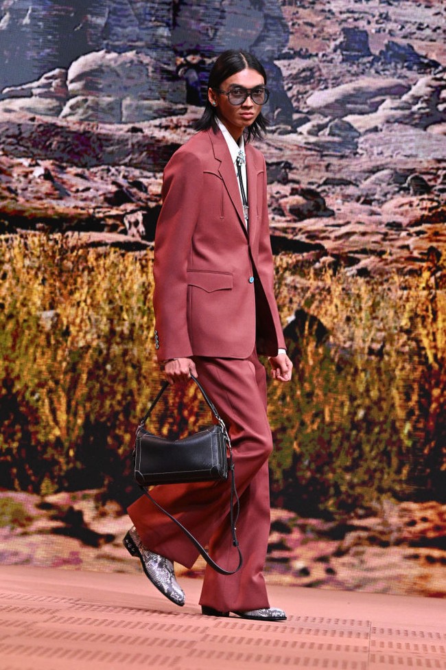 Raihan muncul di catwalk dalam balutan setelan coklat bergaya koboi yang dipermanis dengan dasi bergaya pita. Untuk koleksi ketiganya, Pharrell menggali inspirasi dari Wild West yang identik dengan kultur koboi dan Indian. (Foto: Stephane Cardinale/Corbis via Getty Images)