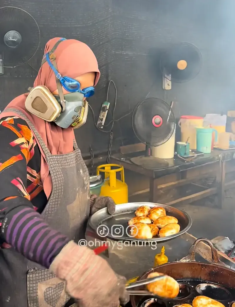 Penjual kue memakai masker hazmat