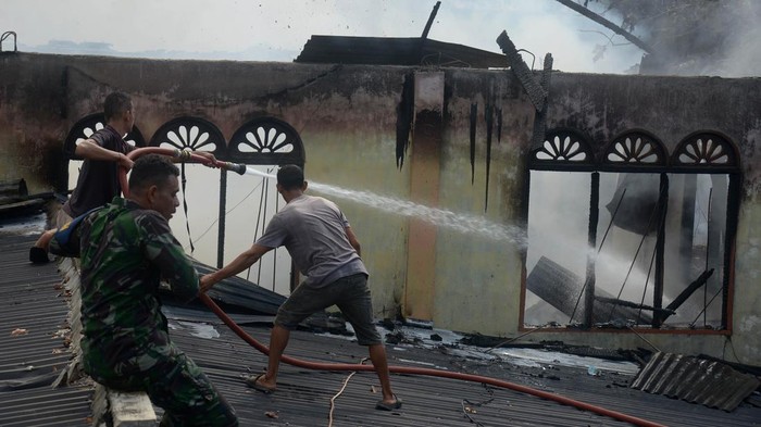 Petugas memadamkan sisa api saat kebakaran Pondok Pesantren Babul Maghfirah di desa Cot Keueng, kabupaten Aceh Besar, Aceh, Kamis (25/1/2024). Kebakaran tersebut menghanguskan dua gedung asrama pelajar Pondok Pesatren Babul Maghrifah dan dua pelajar mengalami cidera  karena melompat dari bangunan saat terjadi  kebakaran sementara sebagian buku pelajaran, pakaian dan lemari berhasil diselamatkan. ANTARA FOTO/Ampelsa/foc.