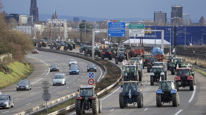 Farmers drive their tractors on the highway Wednesday, Jan. 24, 2024 near Strasbourg; eastern France. French farmers staged protests Wednesday across the country and in Brussels against low wages and what they consider to be excessive regulation, mounting costs and other problems. (AP Photo/Jean-Francois Badias)