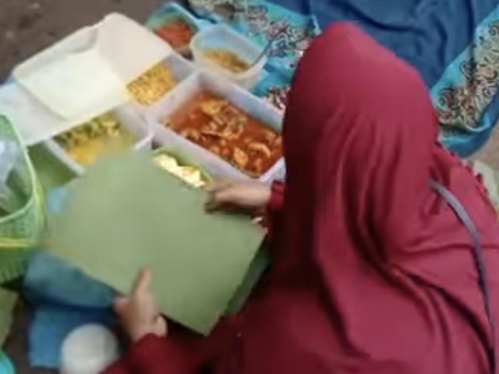 Wanita menjual makanan di tengah jalan Poros Maros-Bone.