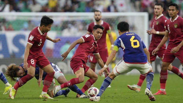 Indonesias Marselino Ferdinan, centre, battles for the ball with Japans Wataru Endo during the Asian Cup Group D soccer match between Japan and Indonesia at Al Thumama in Doha, Qatar, Wednesday, Jan. 24, 2024. (AP Photo/Thanassis Stavrakis)