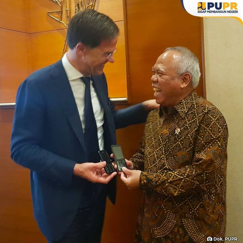 Mark Rutte dan Basuki Hadimuljono sama-sama memakai ponsel jadul, foto tahun 2019 silam. . (Dok akun Facebook Kemen PUPR)