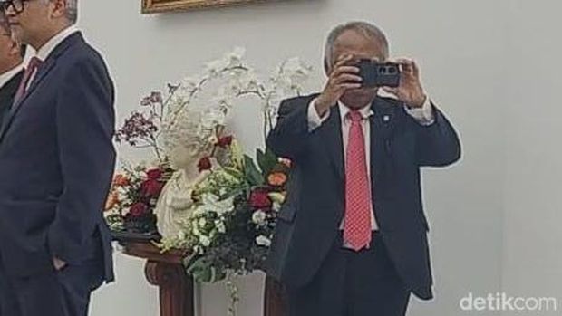 Menteri PUPR Basuki menggunakan ponsel pintar. (Eva Safitri/detikcom)
