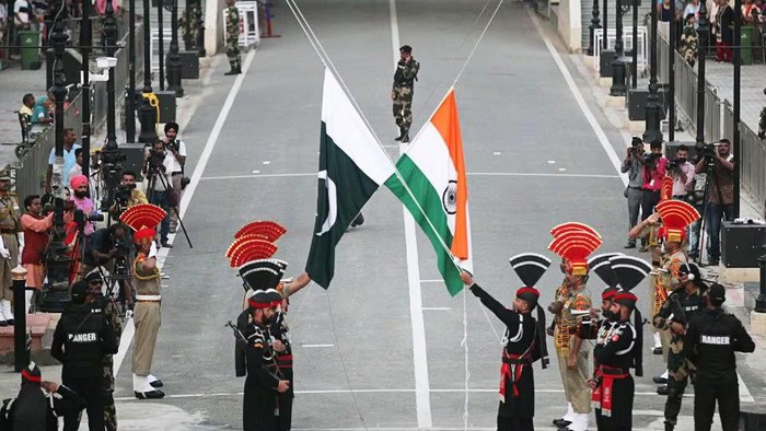 Pakistani Rangers (wearing black uniforms) and Indian Border Security Force (BSF) officers lower their national flags during parade on the Pakistans 72nd Independence Day, at the Pakistan-India joint check-post at Wagah border, near Lahore, Pakistan August 14, 2019. REUTERS/Mohsin Raza Acquire Licensing Rights