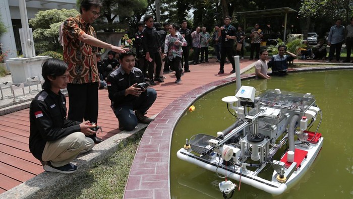 Tim Barunastra ITS Sandi Christanto (kanan), Andi Abdillah (tengah) dan Fajri Romadlon (kiri) menguji coba Nala Proteus 2.0 di kolam Rektorat ITS, Surabaya, Jawa Timur, Jumat (26/1/2024). Kapal permukaan tanpa awak yang dilengkapi dengan sistem perangkat lunak yang mengintegrasikan kecerdasan buatan serta mencapai kecepatan hingga 5 knot tersebut dipersiapkan tim Barunastra ITS untuk mengikuti ajang International Roboboat Competition pada 5-11 Februari di Florida Amerika Serikat. ANTARA FOTO/Moch Asim/foc.