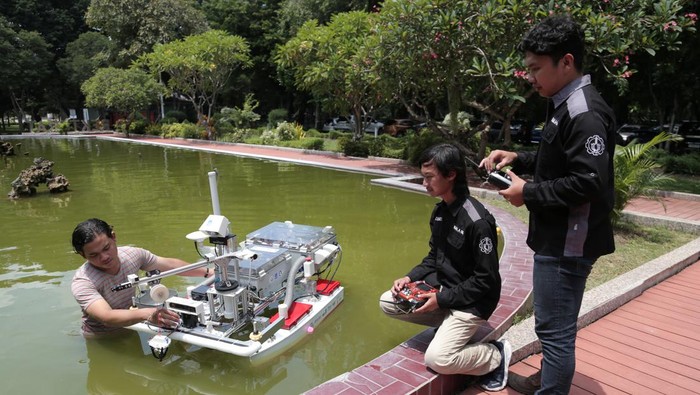Tim Barunastra ITS Sandi Christanto (kanan), Andi Abdillah (tengah) dan Fajri Romadlon (kiri) menguji coba Nala Proteus 2.0 di kolam Rektorat ITS, Surabaya, Jawa Timur, Jumat (26/1/2024). Kapal permukaan tanpa awak yang dilengkapi dengan sistem perangkat lunak yang mengintegrasikan kecerdasan buatan serta mencapai kecepatan hingga 5 knot tersebut dipersiapkan tim Barunastra ITS untuk mengikuti ajang International Roboboat Competition pada 5-11 Februari di Florida Amerika Serikat. ANTARA FOTO/Moch Asim/foc.