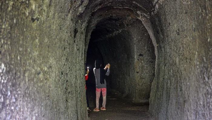 Pengunjung berfoto di depan goa peninggalan Jepang di Taman Hutan Raya Djuanda, Kabupaten Bandung, Jawa Barat, Sabtu (27/1/2024). Kompleks goa militer pada masa penjajahan Jepang yang dibangun pada 1942  dengan cara melubangi dinding dan memiliki empat pintu tersebut saat ini dikelola oleh Taman Hutan Raya Djuanda yang menjadi tujuan utama wisata sejarah penjajahan Republik Indonesia. ANTARA FOTO/Raisan Al Farisi/nz