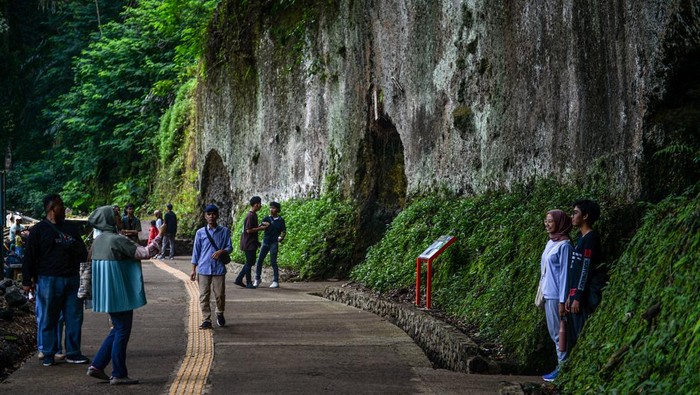 Pengunjung berfoto di depan goa peninggalan Jepang di Taman Hutan Raya Djuanda, Kabupaten Bandung, Jawa Barat, Sabtu (27/1/2024). Kompleks goa militer pada masa penjajahan Jepang yang dibangun pada 1942  dengan cara melubangi dinding dan memiliki empat pintu tersebut saat ini dikelola oleh Taman Hutan Raya Djuanda yang menjadi tujuan utama wisata sejarah penjajahan Republik Indonesia. ANTARA FOTO/Raisan Al Farisi/nz