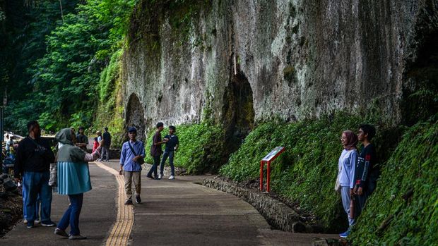 Pengunjung berfoto di depan goa peninggalan Jepang di Taman Hutan Raya Djuanda, Kabupaten Bandung, Jawa Barat, Sabtu (27/1/2024). Kompleks goa militer pada masa penjajahan Jepang yang dibangun pada 1942  dengan cara melubangi dinding dan memiliki empat pintu tersebut saat ini dikelola oleh Taman Hutan Raya Djuanda yang menjadi tujuan utama wisata sejarah penjajahan Republik Indonesia. ANTARA FOTO/Raisan Al Farisi/nz
