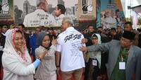 Calon presiden nomor urut 3 Ganjar Pranowo (tengah) didampingi Dewan Penasihat TPN Yenny Wahid (kiri) menunjukkan harapan masyarakat yang ditulis dipunggungnya.