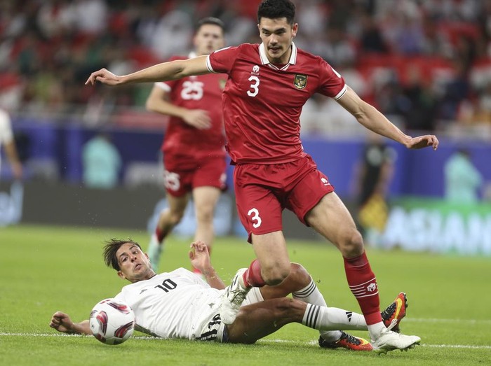 Indonesias Elkan Baggott dribbles Iraqs Mohanad Ali Kadhim during the Asian Cup Group D soccer match between Indonesia and Iraq at Ahmad Bin Ali Stadium in Al Rayyan, Qatar, Monday, Jan. 15, 2024. (AP Photo/Hussein Sayed)