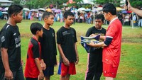 Sebelum pertandingan dimulai, Jokowi menyempatkan untuk bersalaman dan membagikan kaus ke anak-anak yang sedang bertanding.