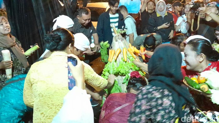 Warga berebut gunungan hasil bumi di kirab Umbul Mantran, Solo, Sabtu (27/1/2024).