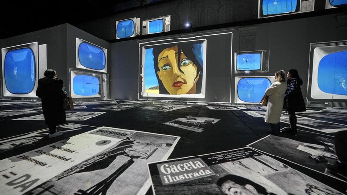 Visitors watch digital multimedia artworks projected on the walls of a former steelworks featuring Spanish surrealist artist Salvador Dali at the Phoenix des Lumieres, located in a former puddling and rolling mill, in Dortmund, Germany, Thursday, Jan. 25, 2024. (AP Photo/Martin Meissner)