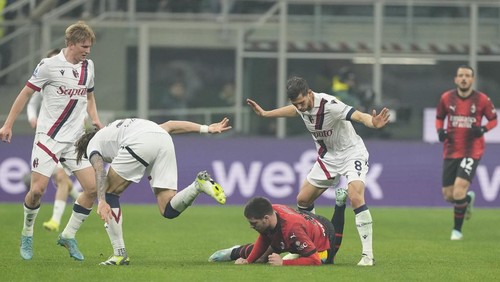 AC Milans Luka Jovic, bottom, is challenged by Bolognas Remo Freuler, right, during the Serie A soccer match between AC Milan and Bologna at the San Siro stadium, in Milan, Italy, Saturday, Jan. 27, 2024. (AP Photo/Antonio Calanni)