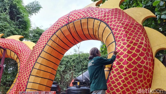 Seorang pekerja sedang Dinas Lingkungan Hidup (DLH) Pemkot Surabaya sedang menyelesaikan pembuatan Lion Naga 3D untuk menyambut Imlek, Minggu (28/1/2024).
